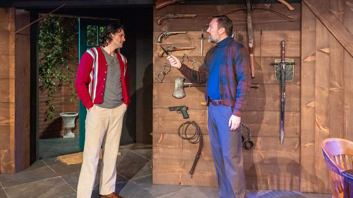 Actors Dan Fagan and Casey McClellan inspect murder weapons in “Deathtrap.”