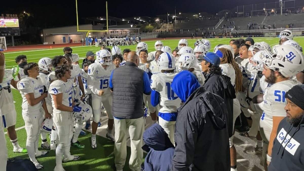 Capital Christian coach Saul Patu talks to his players after beating Wood in the playoffs on Nov. 4, 2022.
