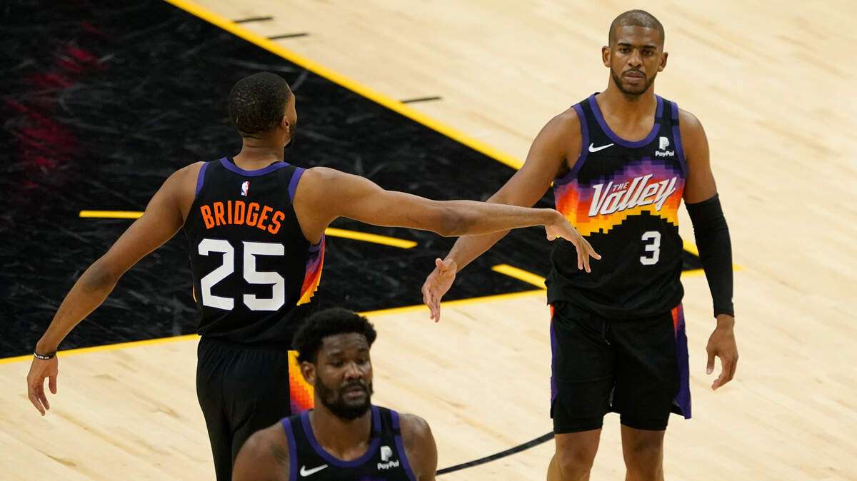 Phoenix Suns guard Chris Paul (3) is greeted by teammate forward Mikal Bridges (25) during the second half of an NBA basketball game against the Los Angeles Clippers, Wednesday, April 28, 2021, in Phoenix. (AP Photo/Matt York)