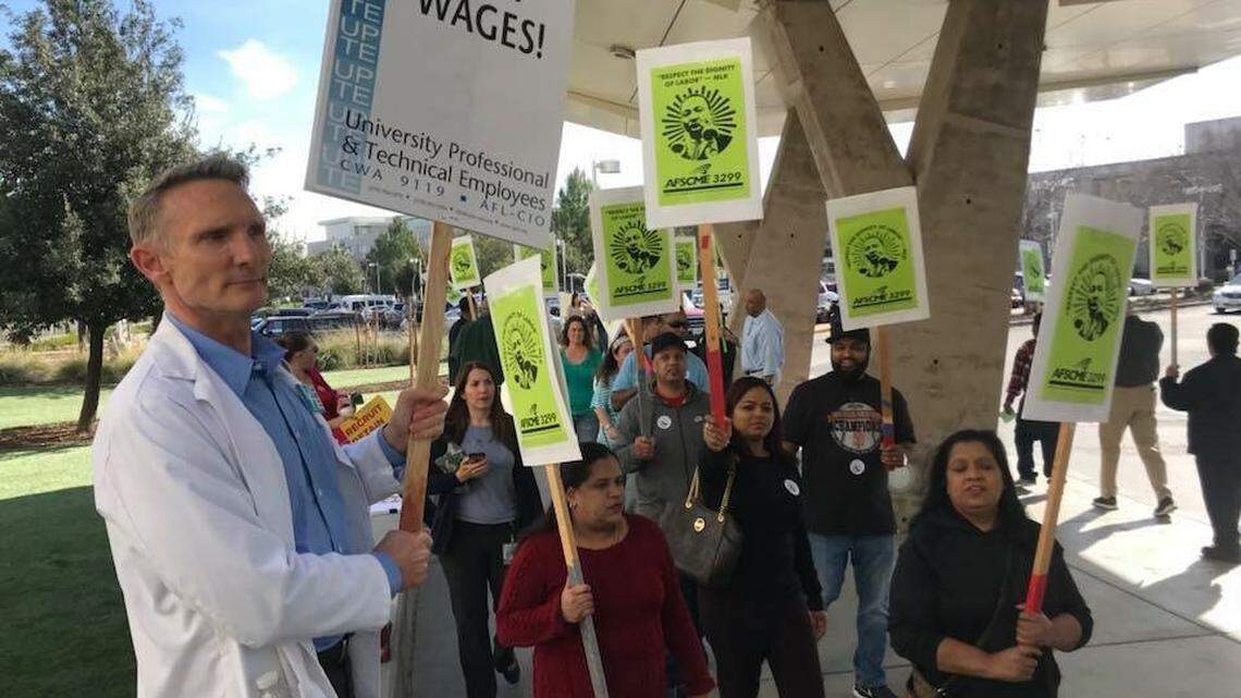 Senior dietitian Greg Wine, a negotiator representing UPTE-CWA’s medical center employees, left, joins members of AFSCME 3299 in protesting at the UC Davis Medical Center.