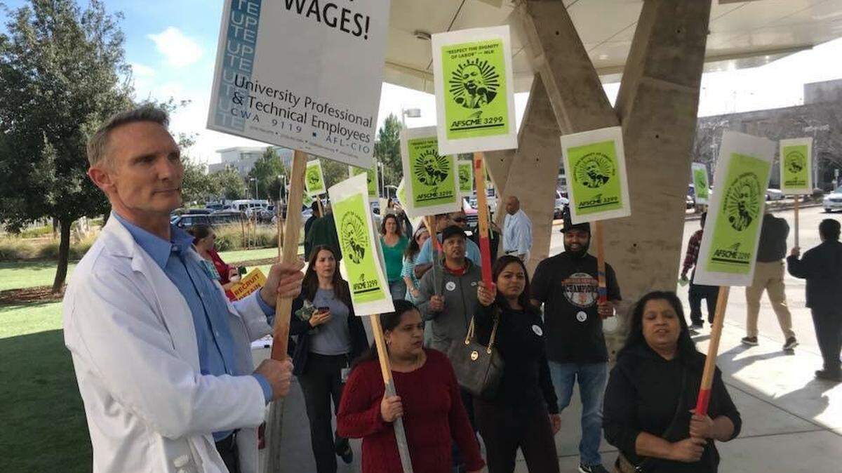 Senior dietitian Greg Wine, a negotiator representing UPTE-CWA’s medical center employees, left, joins members of AFSCME 3299 in protesting at the UC Davis Medical Center.