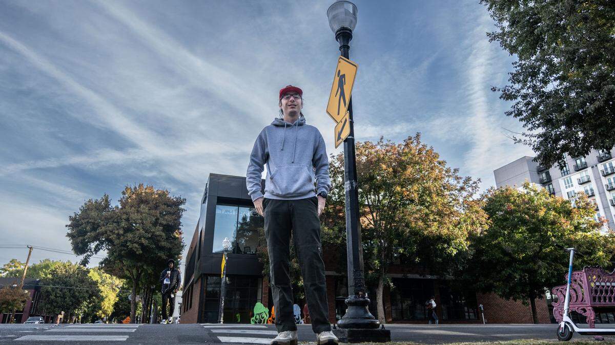 TikToker Logan Ivey stands Friday near a street lamp on J Street in midtown Sacramento that was fixed after he featured it in a viral video. It is one of several locations that has received city attention because of his social media efforts.