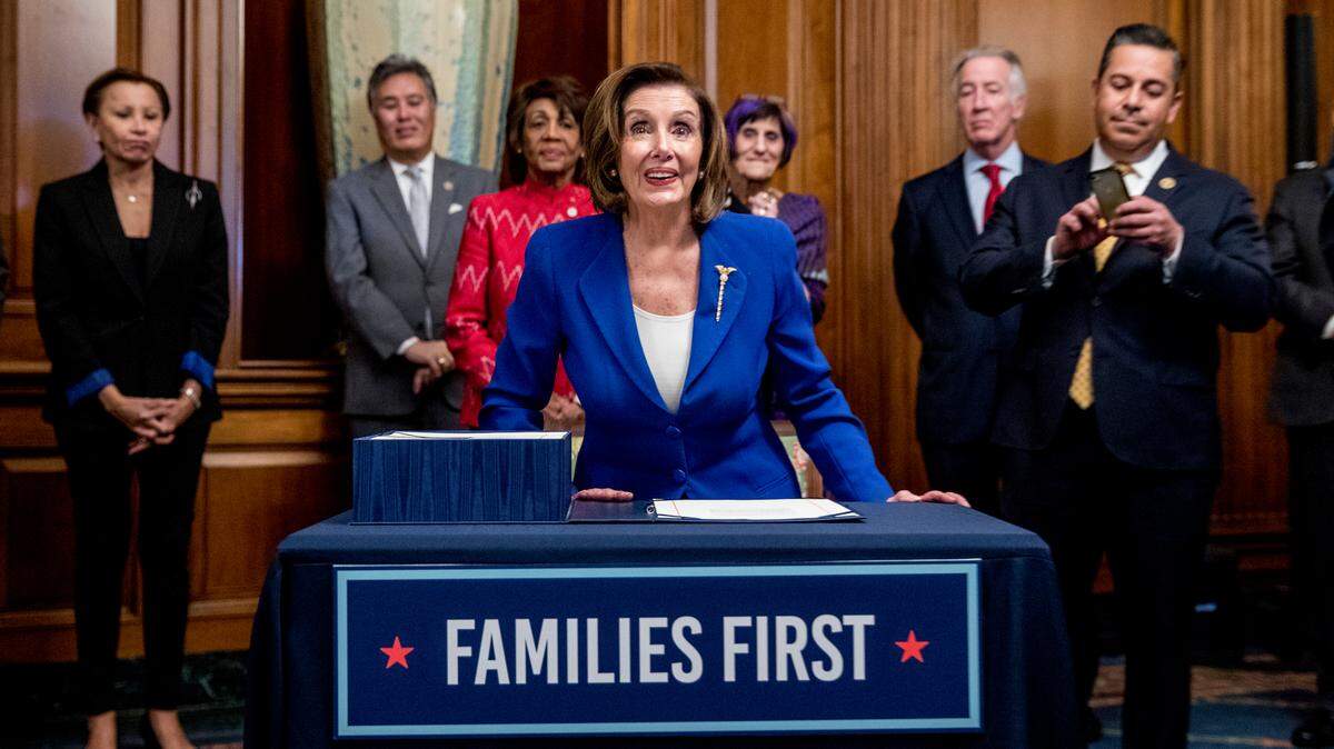 House Small Business Committee Chair Nydia Velazquez, D-N.Y., left, accompanied by other legislators, watches as House Speaker Nancy Pelosi of Calif., center, stands after signing the Coronavirus Aid, Relief, and Economic Security (CARES) Act after it passed in the House on Capitol Hill, Friday, March 27, 2020, in Washington. Velazquez, who attended last Friday’s $2 trillion coronavirus economic aid bill enrollment ceremony on Capitol Hill with Speaker Pelosi, House Majority Leader McCarthy and House Majority Leader Steny Hoyer, say she has been diagnosed with COVID-19. (AP Photo/Andrew Harnik)