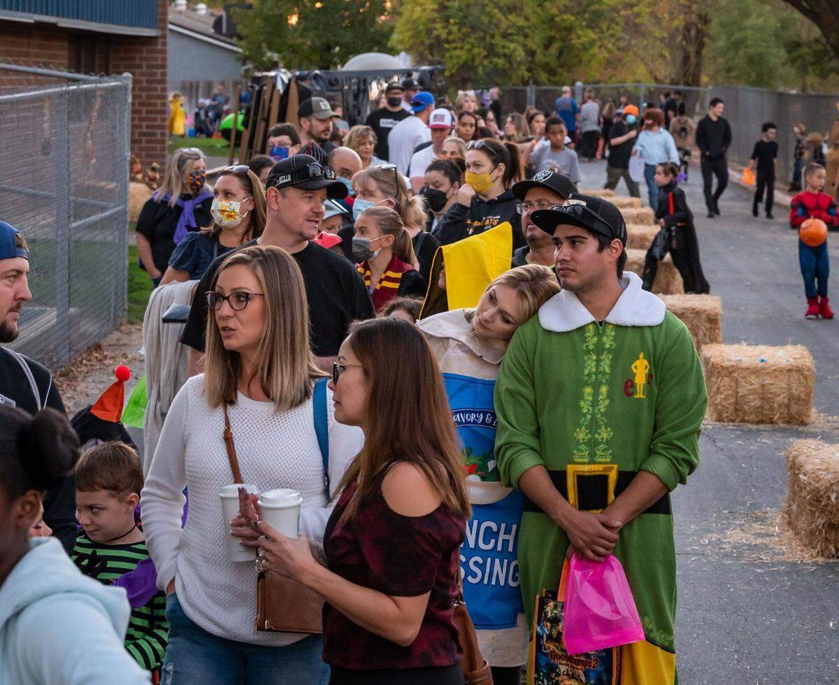 Families stand in line to enter the Florence Markofer Elementary School parent teacher organization’s first Trunk or Treat outdoor fundraiser Oct. 15 at the school in Elk Grove. Danielle Feist, attending with Jordan Escorcia, right, and their 5-year-old student Hayden Feist, said they haven’t had the opportunity to support the school at events lately due to COVID-19.