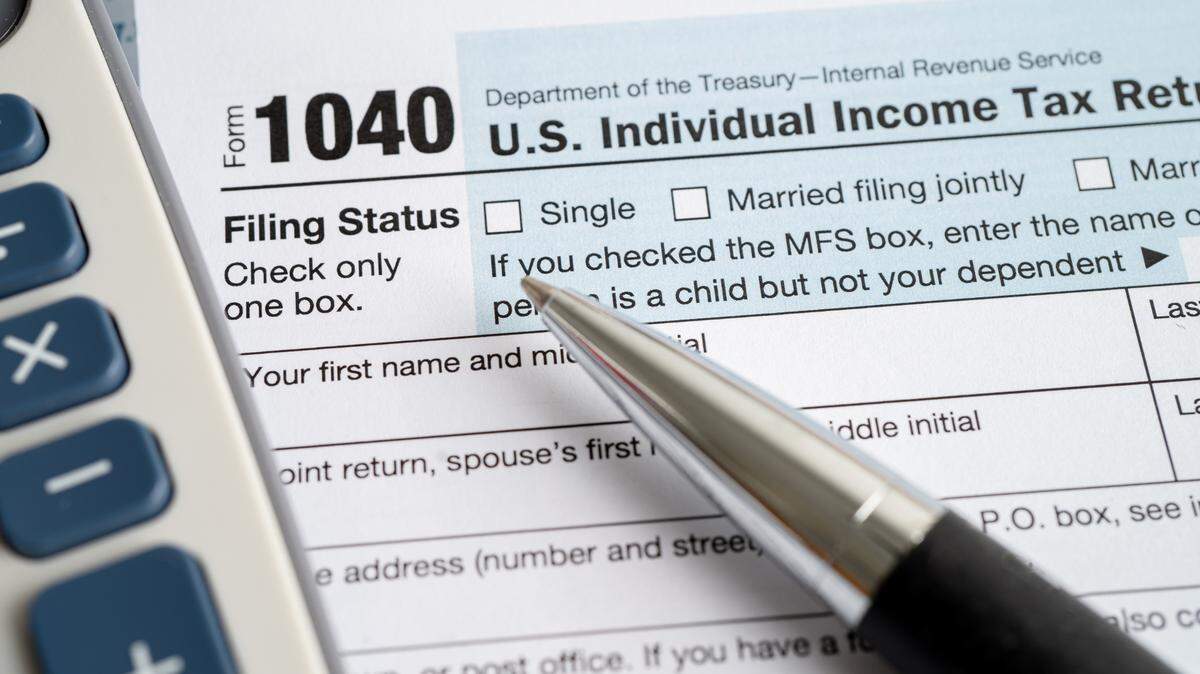Tax Return form 1040 with USA America flag and dollar banknote, U.S. Individual Income.