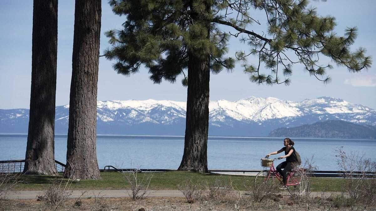 A cyclist rides along a bike trail near Highway 50 in South Lake Tahoe. The City Council this week approved a new ordinance reopening vacation home rental permits to some former operators after a judge struck down Measure T.