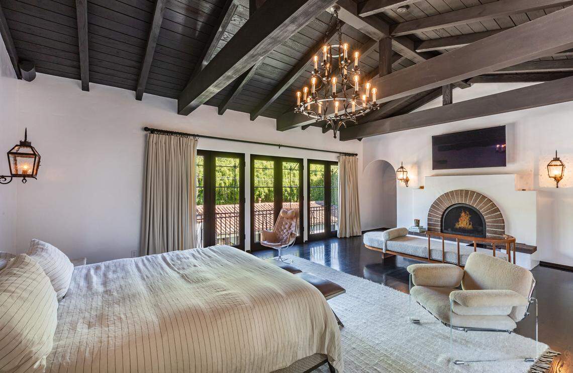 Archways, soaring truss ceilings, wrought-iron accents and hardwood and terracotta floors are found throughout the Spanish Revival-style home.