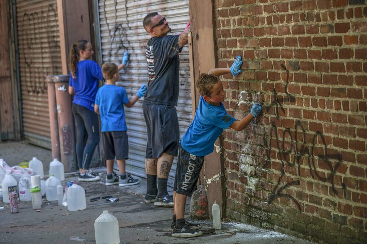 20. Joshua Vanek cleans graffiti with his children Weston Vanek, 10, right, Holley Vanek, 11, left, and Hunter Varek, 7, center, along Q Street in Sacramento on Wednesday, June 3, 2020. “I just feel like this was the right thing to do,” said the single father from Lincoln after hearing about vandalism to the city following protests over the death of George Floyd.