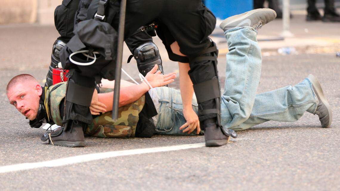 Police restrain Jeffrey Erik Perrine from the march by Patriot Prayer in Portland, Ore., on Saturday, June 30, 2018. Police dispersed clashing protesters as problems occurred when two opposing protest groups — Patriot Prayer and antifa — took to the streets.
