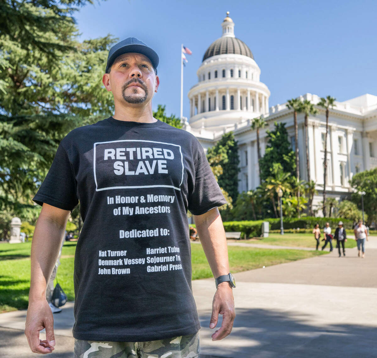 John Vasquez of Sacramento, who has lived experience in the California prison system, wears a “retired slave” T-shirt an event at the state Capitol on Tuesday, Sept. 3, 2024, to support the passage of Proposition 6. The measure would ban involuntary servitude in jails and prisons, where inmates can be punished if they refuse to do compulsory work.