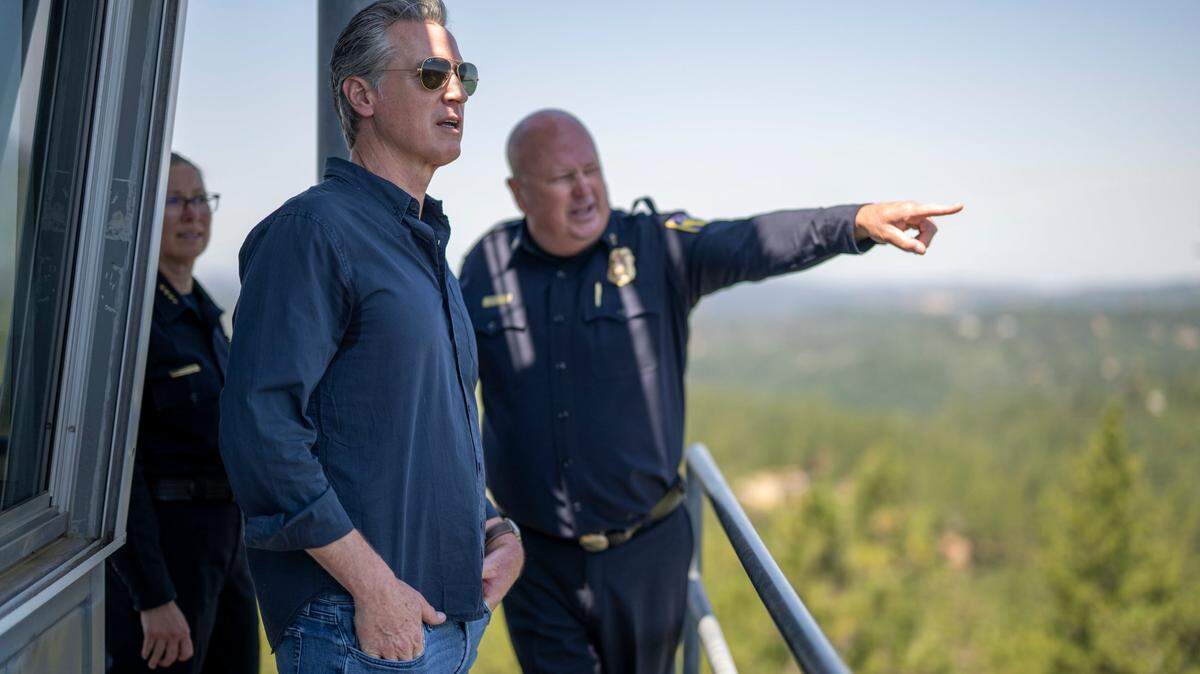 Gov. Gavin Newsom stands atop a fire watch tower with Cal Fire Nevada-Placer Unit Chief Brian Estes following a news conference on the federal government’s role in wildfire prevention on Tuesday, July 1, 2025.