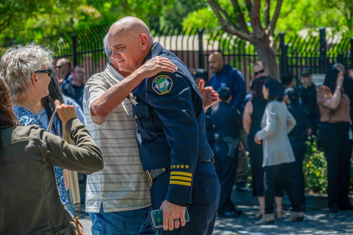 Elk Grove Assistant Police Chief Brian Schopf is hugged after speaking during a dedication honoring fallen Officer Ty Lenehan on Wednesday in Elk Grove. 