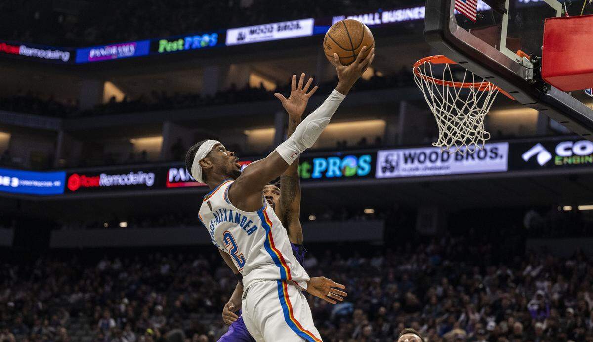 Oklahoma City Thunder guard Shai Gilgeous-Alexander (2) drives to the basket against Sacramento Kings guard Malik Monk (0) during an Emirates NBA Cup in-season tournament game at Golden 1 Center on Friday.