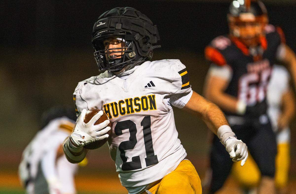 Hughson Huskies running back Eli Wilbanks (21) carries the ball against the Roseville Tigers in a CIF Sac-Joaquin Section Division IV semifinal in Roseville on Friday, Nov. 21, 2025.