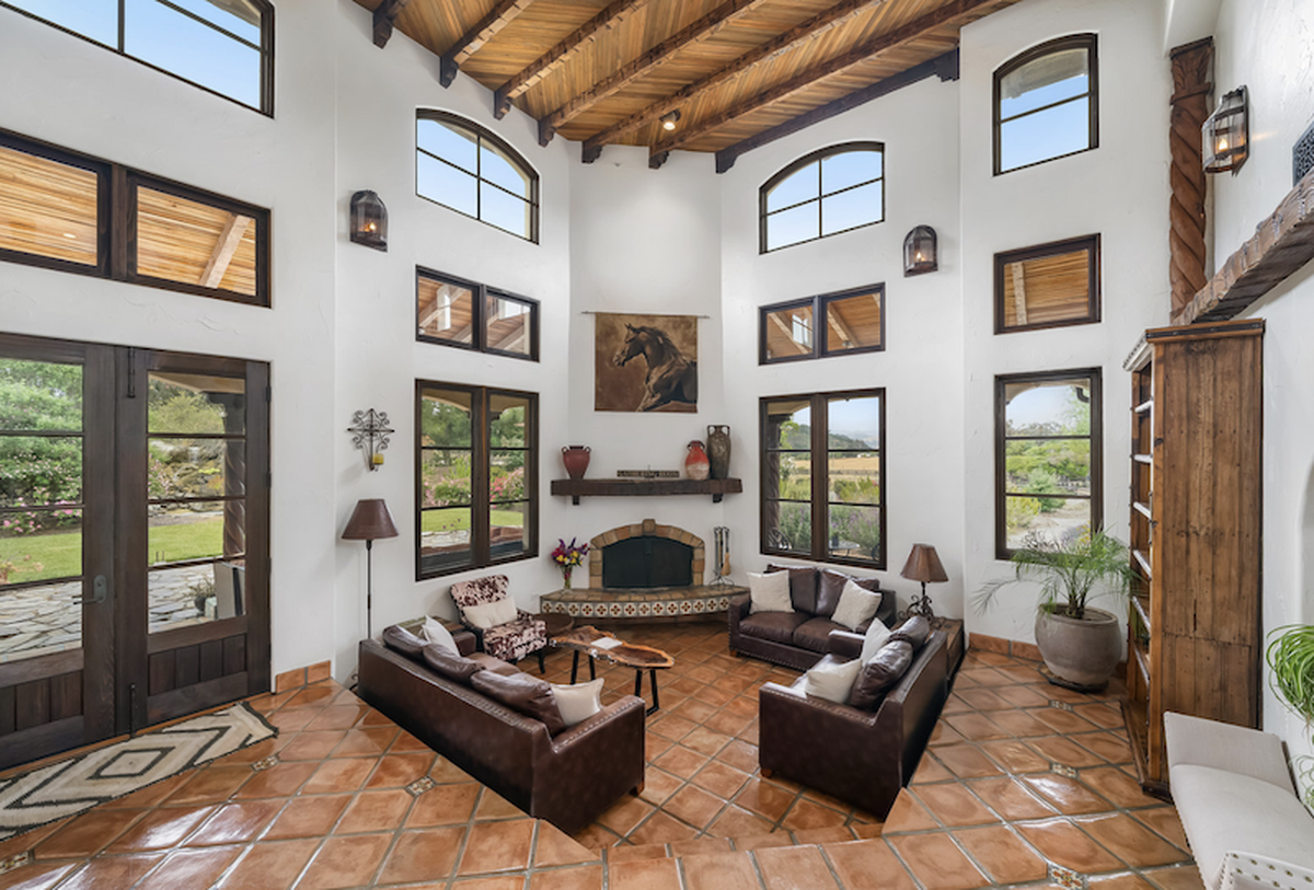 Inside, cathedral ceilings with exposed beams, antique tiles imported from Spain, interior mezzanine balconies, an exquisite winding iron-rail staircase, custom cabinetry and panoramic valley views create a dazzling ambiance.