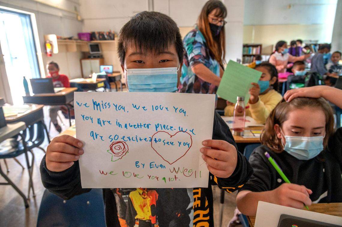 Fourth grader Evan Lee, 9, holds up his letter in anticipation of welcoming Afghan student Pakiza back to Ethel I. Baker Elementary School on Oct. 22. “We miss you. We love you. You are in a better place. We are so excited to see you. We love you a lot,” it reads.