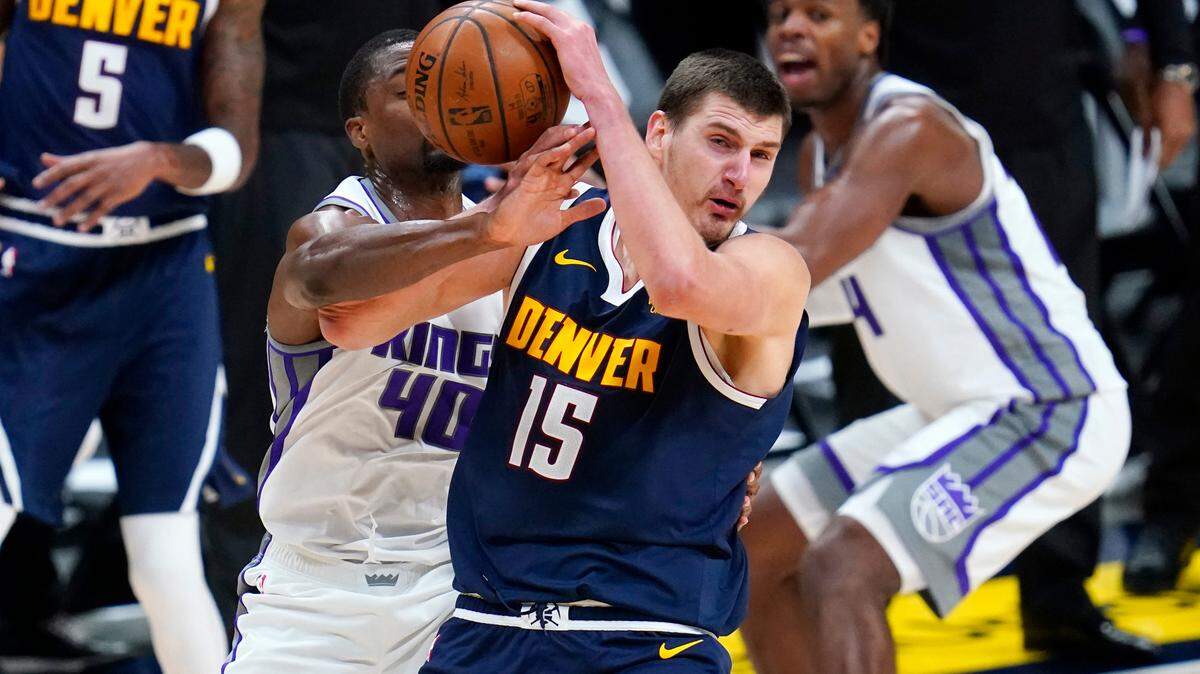 Denver Nuggets center Nikola Jokic, front, loses control of the ball as Sacramento Kings forward Harrison Barnes defends in overtime of an NBA basketball game Wednesday, Dec. 23, 2020, in Denver. (AP Photo/David Zalubowski)