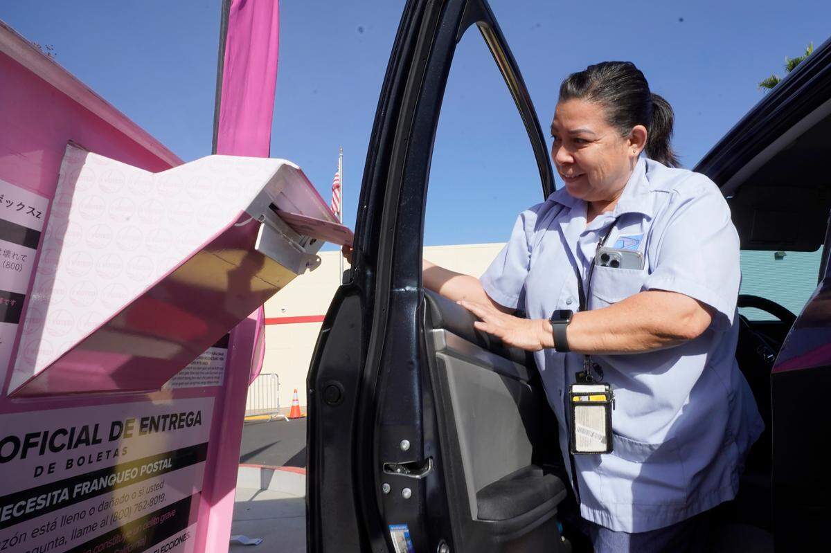 Yvonne Gali steps out of her car to cast her California primary ballot at a drop-off box outside the Sacramento County Registrar of Voters office in Sacramento on Tuesday.