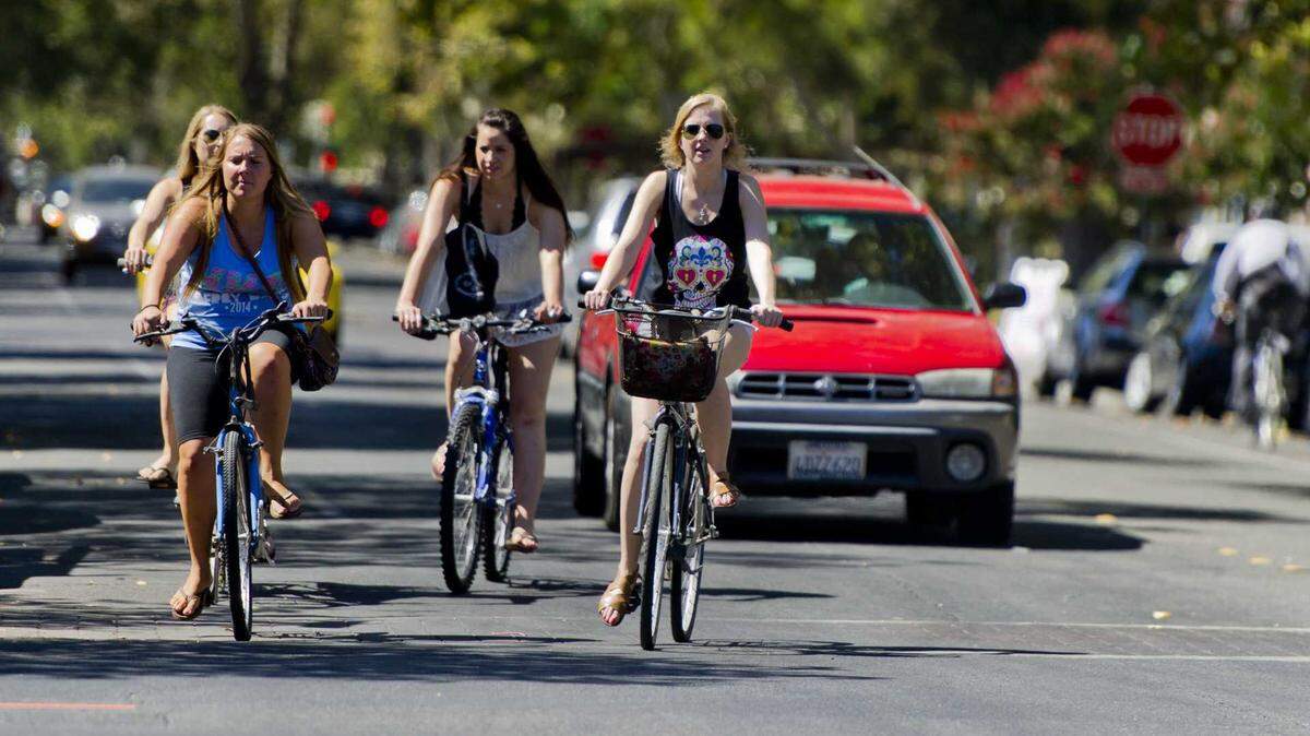 Women ride their bikes through downtown Davis in 2014. The Davis City Council on Tuesday accepted more than $548,000 in state grants to install protected bike lane barriers on Lake Boulevard and upgrade three pedestrian crossings as part of the city’s traffic safety plan.