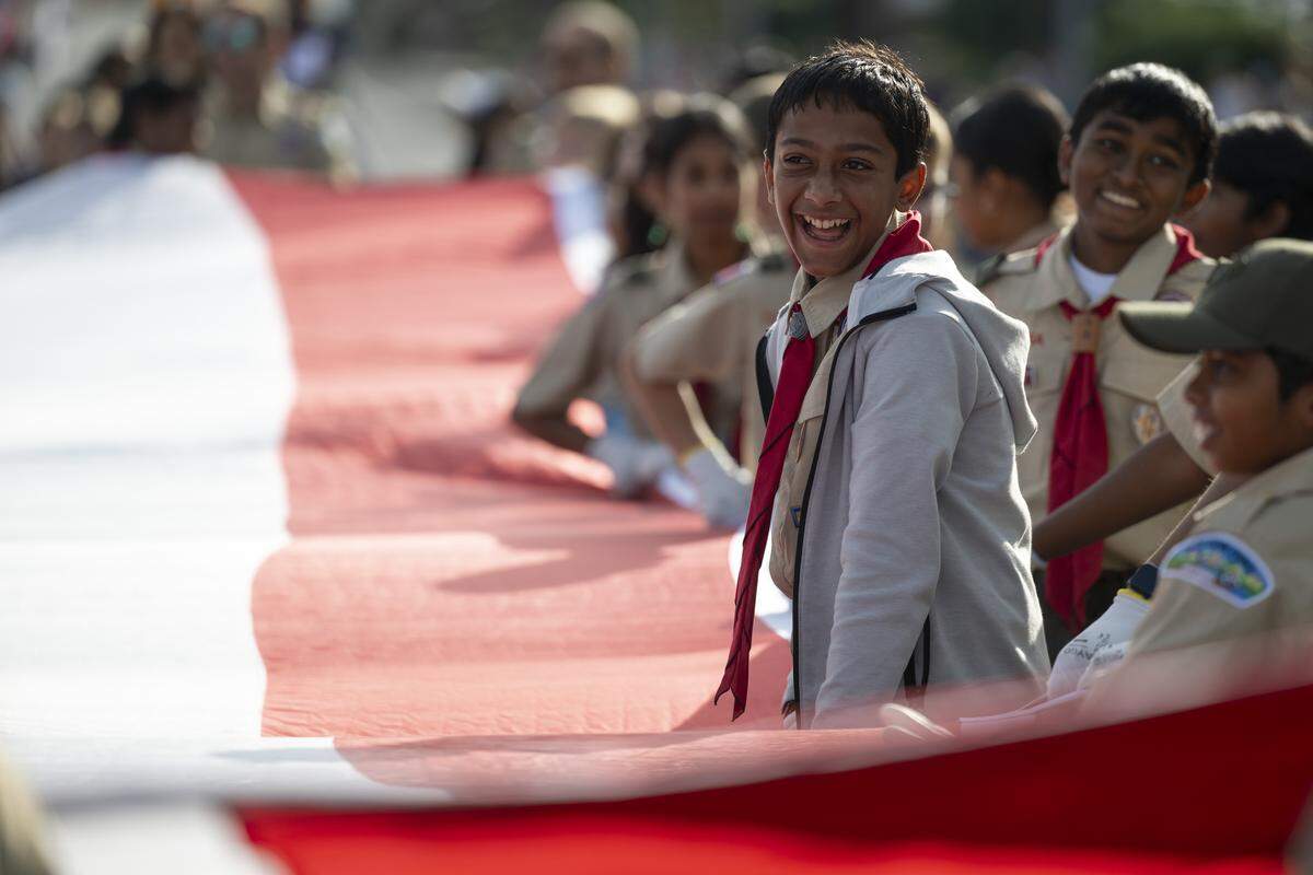 Arjun Ganti, a member of Boy Scout Troop 1855, helps his troop carry an American flag during a Veterans Day parade in Folsom on Tuesday, Nov. 11, 2025.