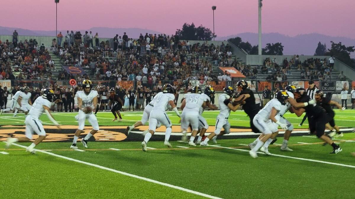 Oak Ridge running back Reece Catchings takes a handoff as the Vacaville defense swarms Friday night.