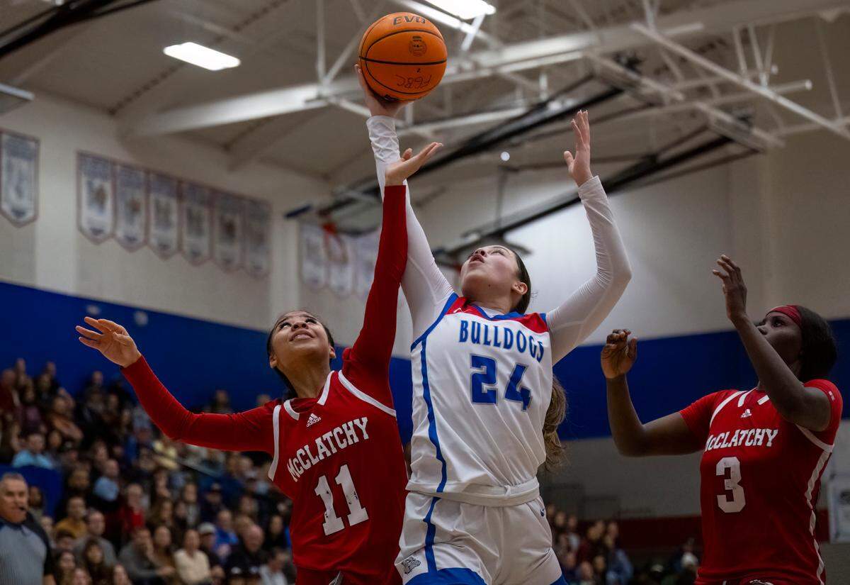 Folsom Bulldogs guard Sophia Mindermann (24) pulls down a rebound against the McClatchy Lions in a 2024 Sac-Joaquin Section girls basketball semifinal. Mindermann is The Bee's Large School Player of the Year.