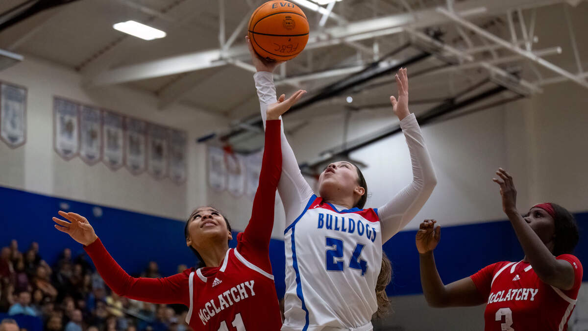Folsom Bulldogs guard Sophia Mindermann (24) pulls down a rebound against McClatchy Lions guard Laila Stancil-Williams (11) in the third quarter of a CIF Sac-Joaquin Section girls basketball semifinal on Monday.