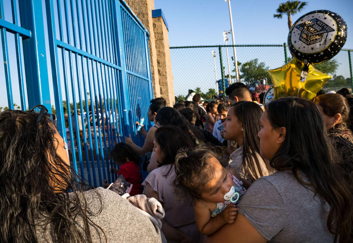 Families and friends look past the gates for glimpses of Grant Union High School graduation seniors during the ceremony Thursday, June 1, 2023, after the stadium was closed, citing capacity, in Sacramento’s Del Paso Heights neighborhood.