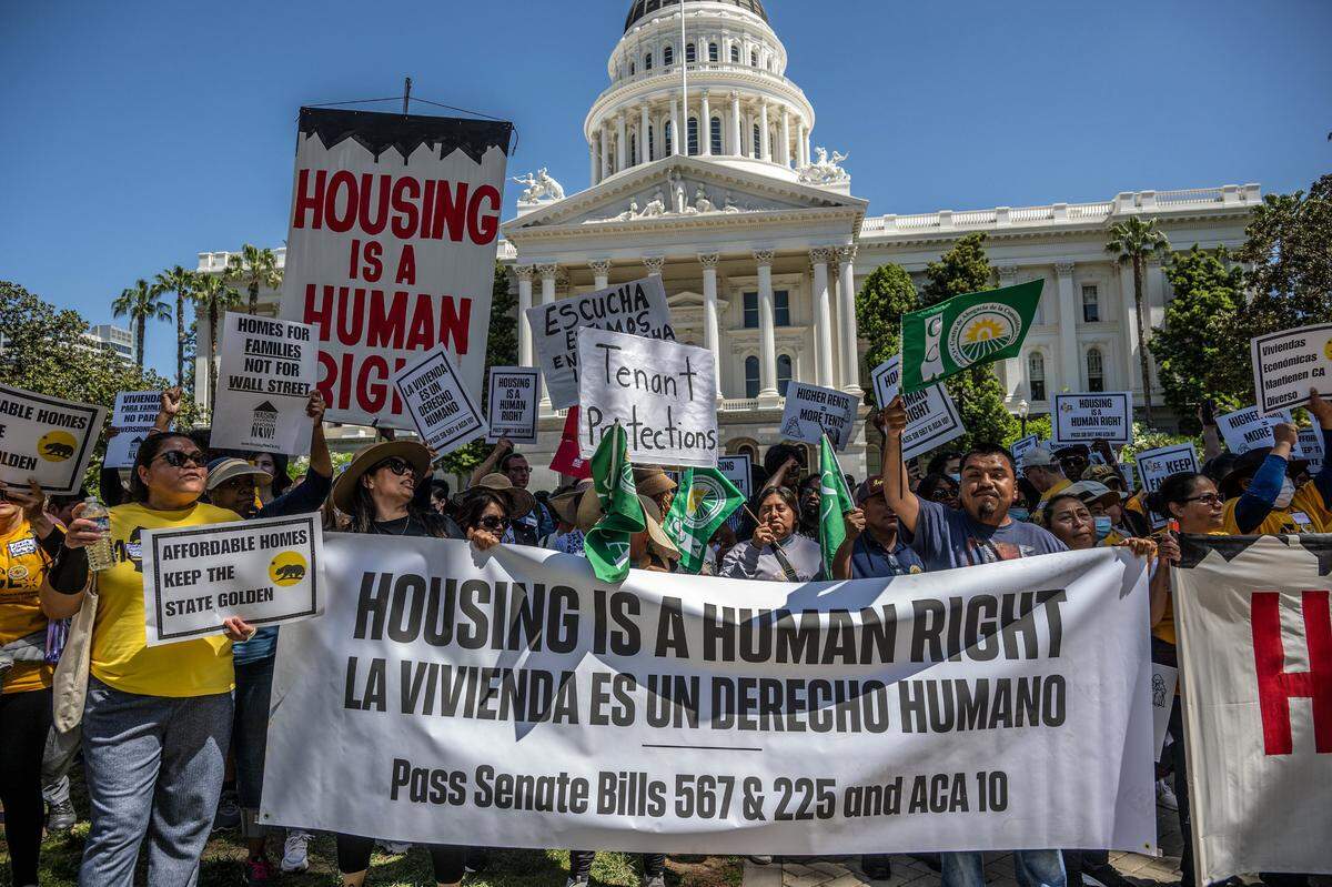 Protesters carry a banner saying “housing is a human right” as they participate in rally Monday at the state Capitol in support of Assembly Constitutional Amendment 10, introduced Assemblyman Matt Haney, D-San Francisco, which would add housing to the rights enumerated in the California Constitution.