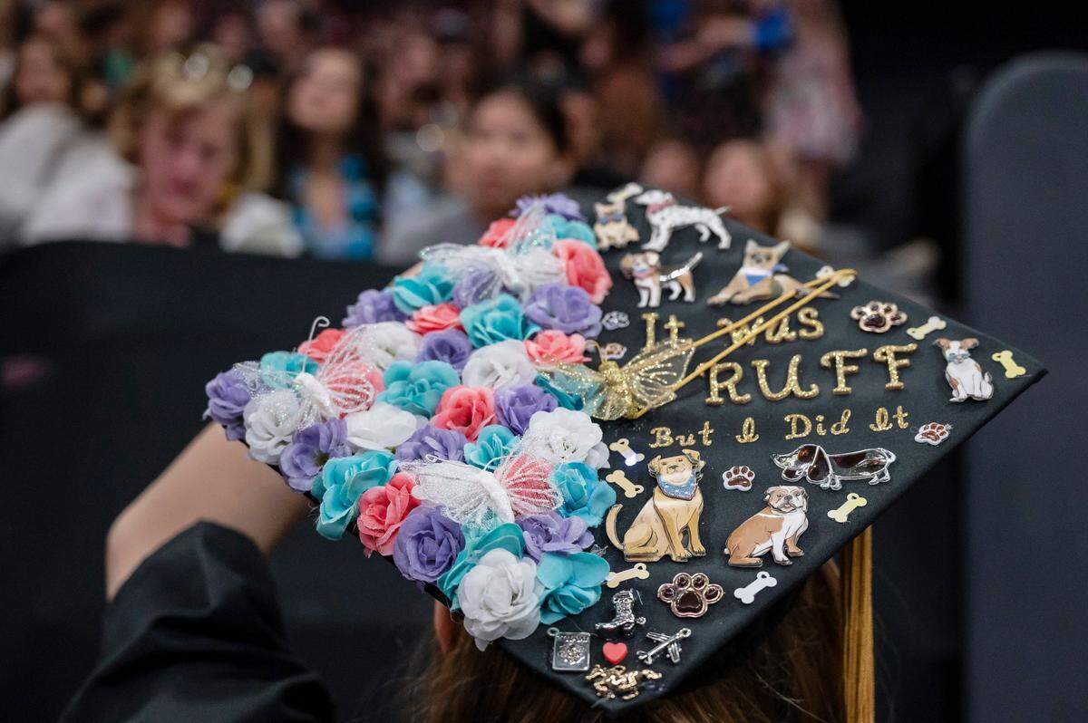 With a decorated cap that says “it was ruff, but I did it,” Savannah Templin looks into the crowd before the Sacramento State College of Business commencement on Friday.