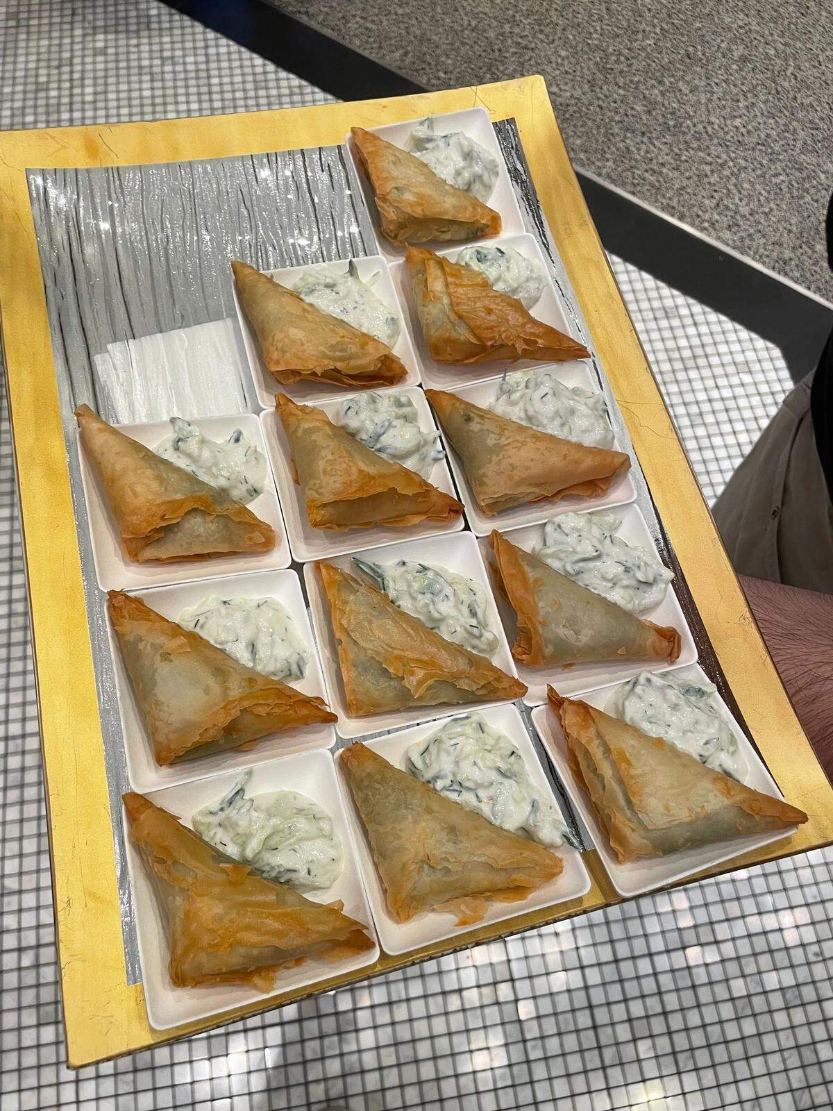A tray of handheld spanakopita is presented as one of Sky River Casino’s newest dishes on Tuesday, Oct. 7, 2025. The casino debuted its brand new Fork on the Road food truck dining concept, which will explore a range of global cuisines, starting with Greek food.