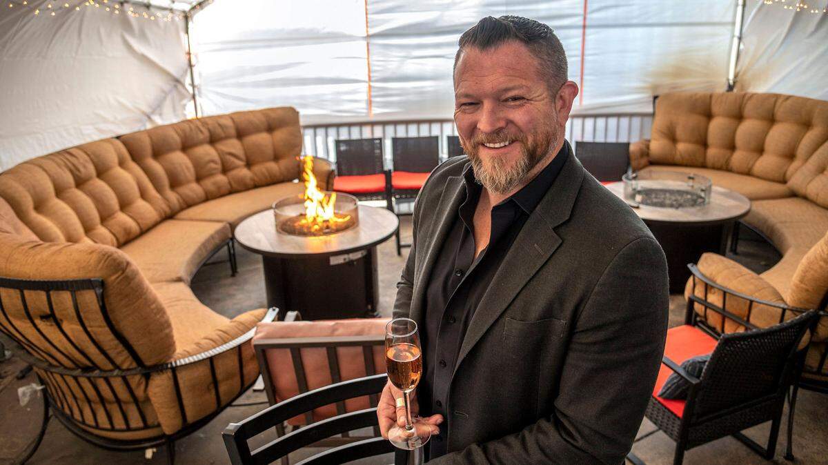 Matthew Oliver, owner of three restaurants in Placer County — House of Oliver, Oliver’s Brewhouse and Grill, and Oliver’s Antler Steakhouse — stands inside a tented outdoor wine lounge at House of Oliver in 2022.
