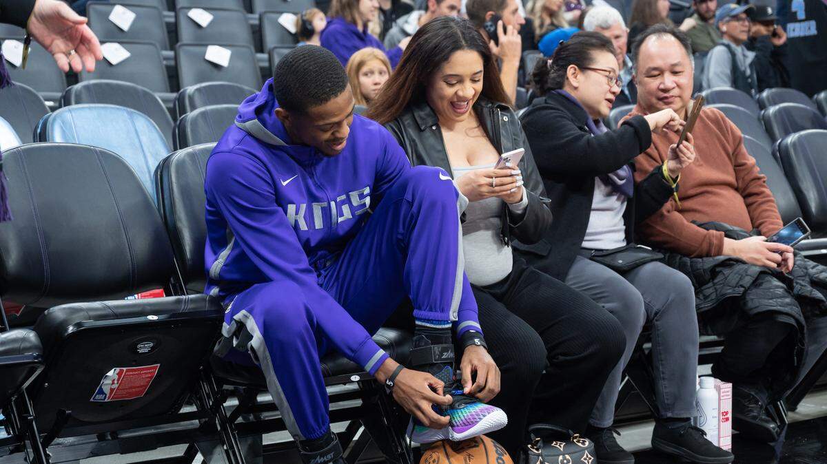 Sacramento Kings guard De’Aaron Fox (5) sits with his wife Recee Caldwell during warmups against the Denver Nuggets in December at Golden 1 Center in Sacramento.