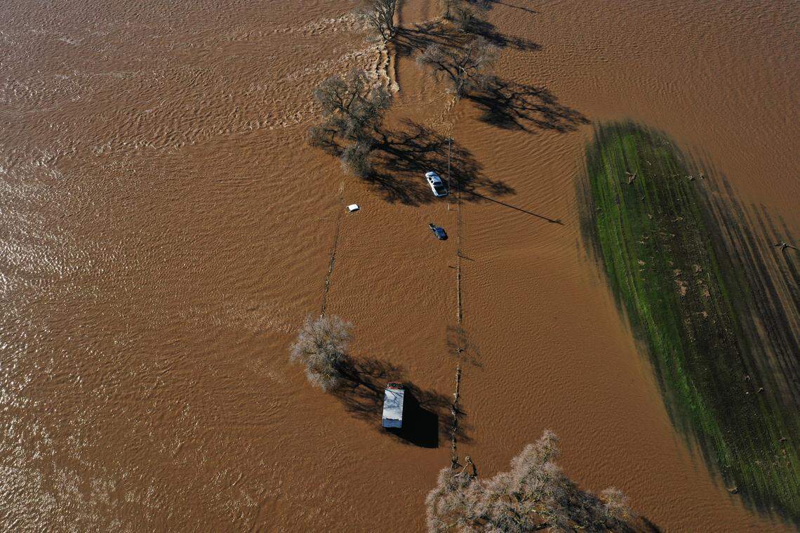 Four vehicles are stuck in floodwaters on Dillard Road west of Highway 99 in south Sacramento County on Sunday, Jan. 1, 2023, after heavy rains produced levee breaks in the area.
