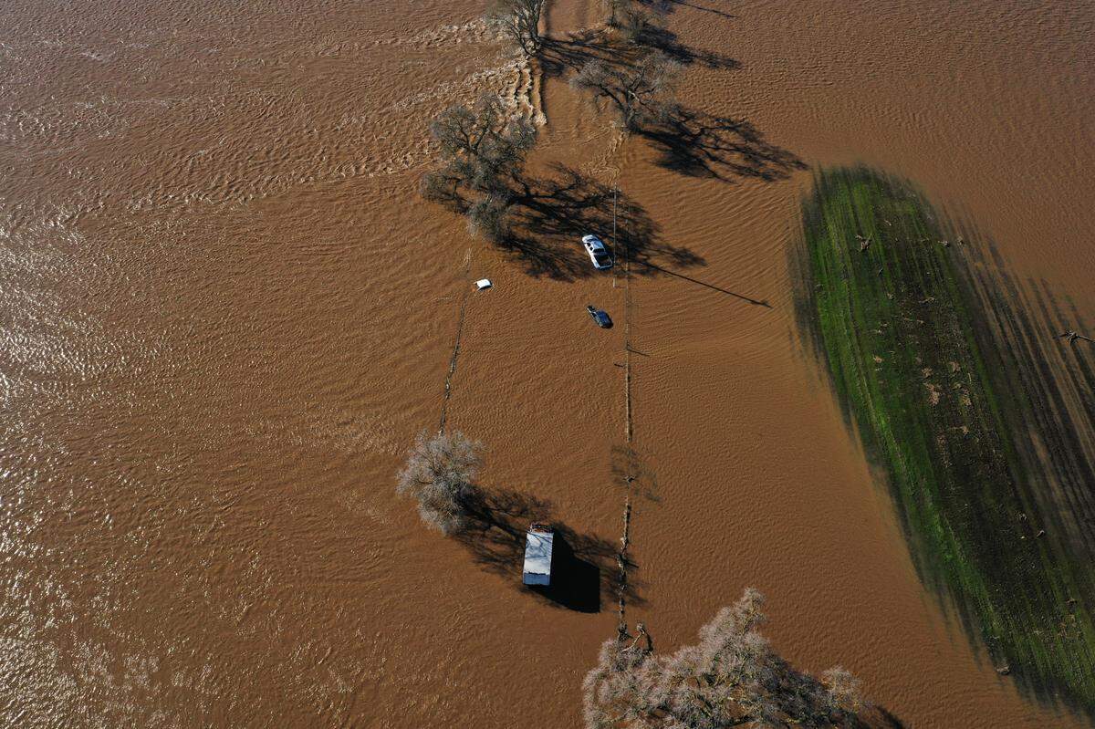 Four vehicles are stuck in floodwaters on Dillard Road west of Highway 99 in south Sacramento County on Sunday, Jan. 1, 2023, after heavy rains produced levee breaks in the area.