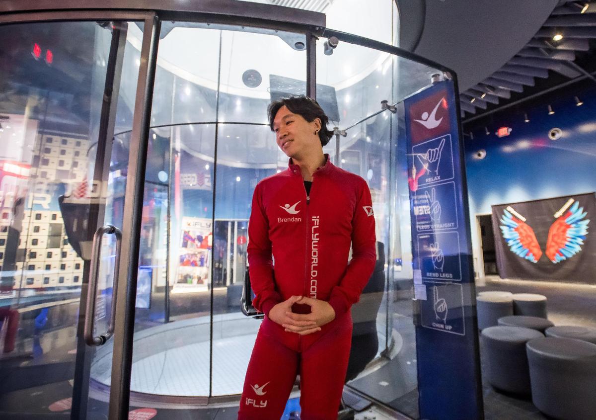 Lead instructor Richard Thai speaks about the experience during an interview at iFly Indoor Skydiving on Sept. 20, 2023, in Roseville. A chart of non-verbal communications are seen behind him in the indoor wind tunnel.