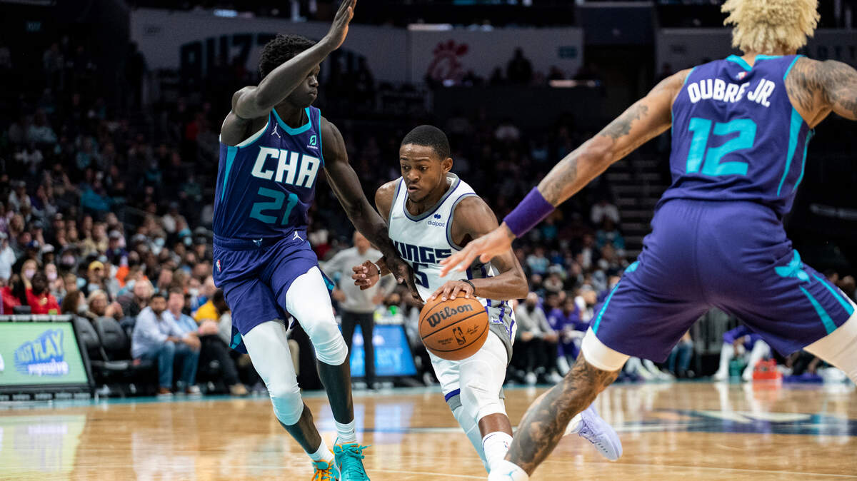 Sacramento Kings guard De’Aaron Fox (5) attempts to dribble between Charlotte Hornets forward JT Thor (21) and guard Kelly Oubre Jr. (12) during the second half of an NBA basketball game, Friday, Dec. 10, 2021, in Charlotte, N.C. (AP Photo/Matt Kelley)