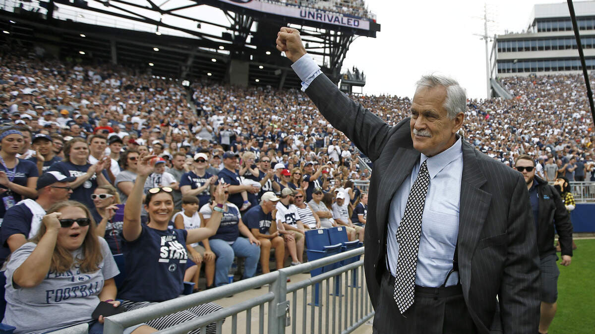 FILE - In this Sept. 1, 2018, file photo, honorary captain and Penn State alumn Matt Millen waves to the crowd before the team takes on Appalachian State in an NCAA college football game in State College, Pa. Millen is stepping away from his TV analyst job for the rest of this season to focus on his health. The Big Ten Network made the announcement Wednesday, Oct. 3, 2018. The 60-year Millen has amyloidosis and has been seeking a heart transplant. (AP Photo/Chris Knight, File)