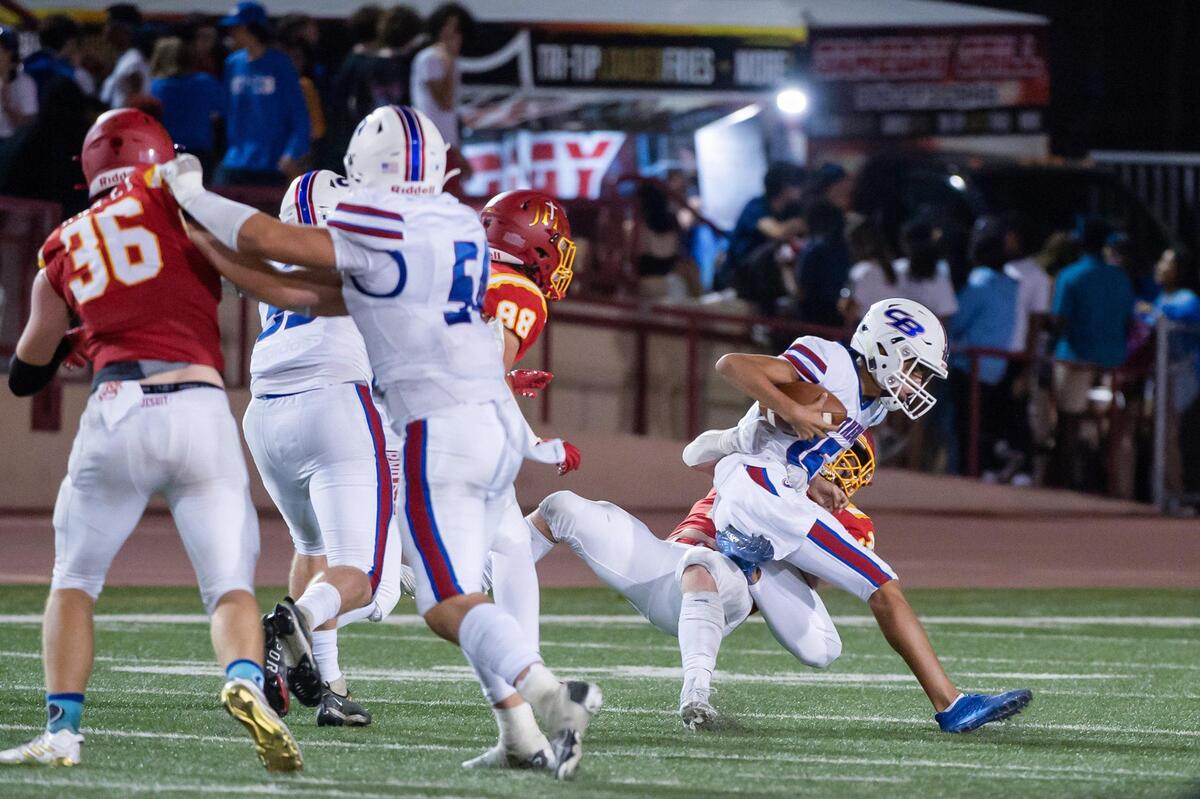 Christian Brothers quarterback Deakon Holden (15) gets sacked by Jesuit’s Jagger Shaddix (32) during the Holy Bowl in September at Sacramento City College. The Marauders won 21-7.