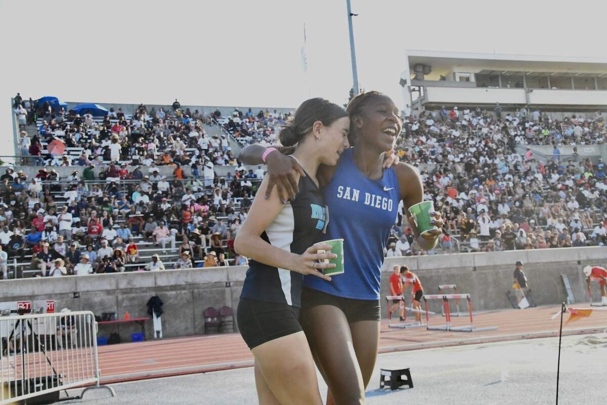 Brooke White of River City High School of West Sacramento, left, embraces CIF State 100-meter hurdles champion Anisa Bowen-Fontenot of San Diego High at the track and field championships Saturday in Clovis. White was second in the hurdles and the long jump.