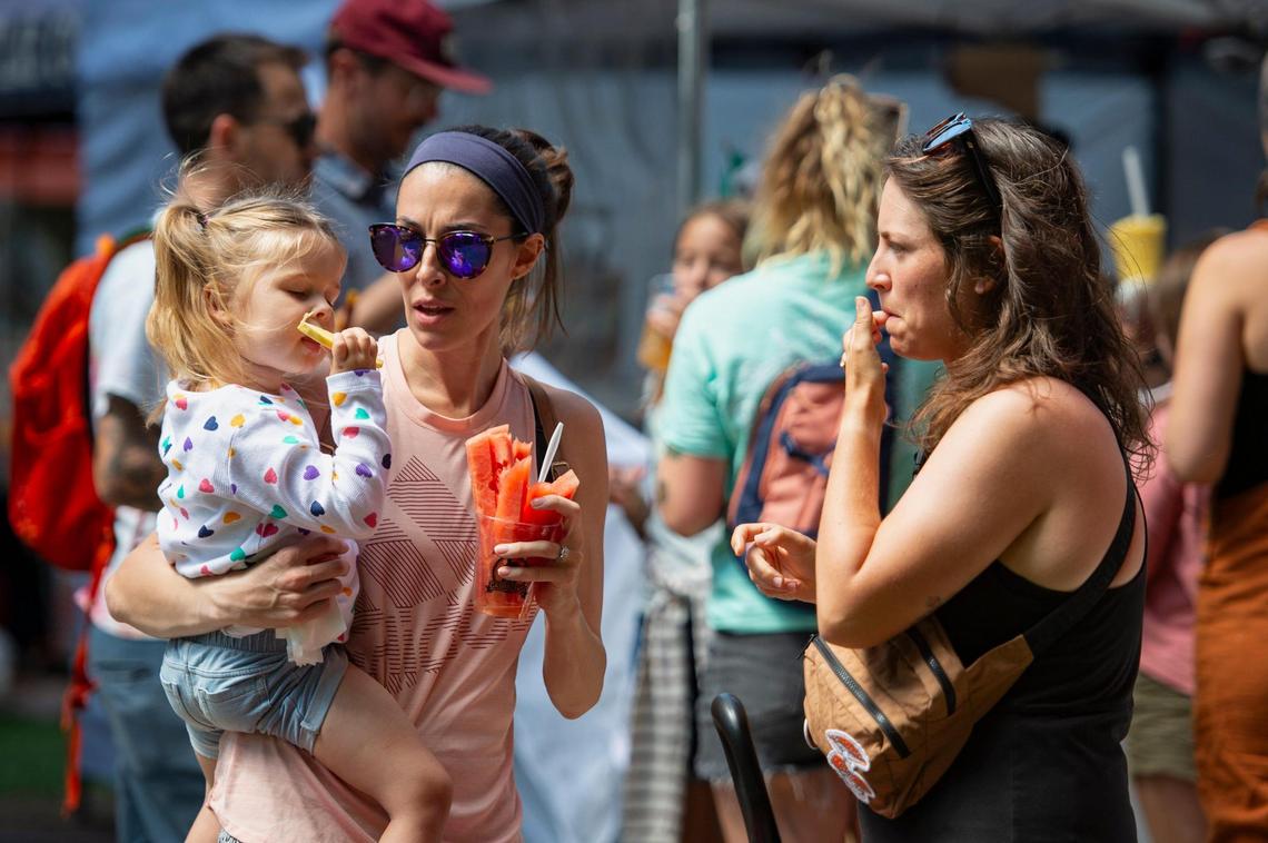 Ashley Mackie, right, of Fairfield, watches as Niccole Macleod, of Vacaville, holds her daughter Freya, 2, as she eats a fruit cup at Chalk It Up on Sunday, Sept. 3, 2023, at Fremont Park in downtown Sacramento.