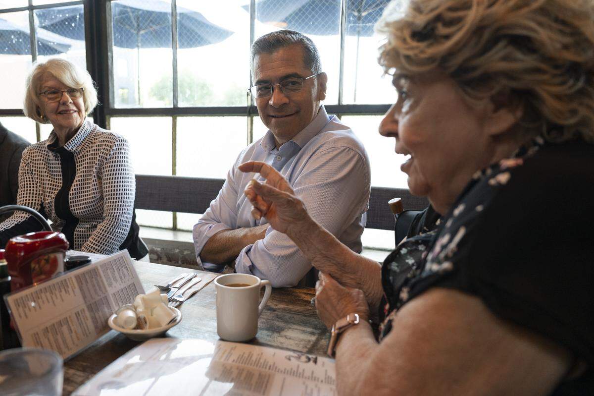 Former state legislator Dede Alpert, left, and Xavier Becerra, center, a former state legislator and former attorney general of California, listen as former state legislator Paula Boland, right, tells a story during a reunion for the California Assembly class of 1990 at Fox & Goose in Sacramento on Wednesday.