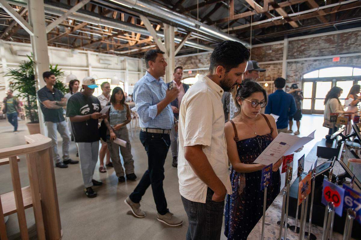 Joe and Monica Preciado of Sacramento view the menu at Slow & Low Smokehouse during the Elk Grove restaurant’s soft opening on Wednesday, May 29, 2024.