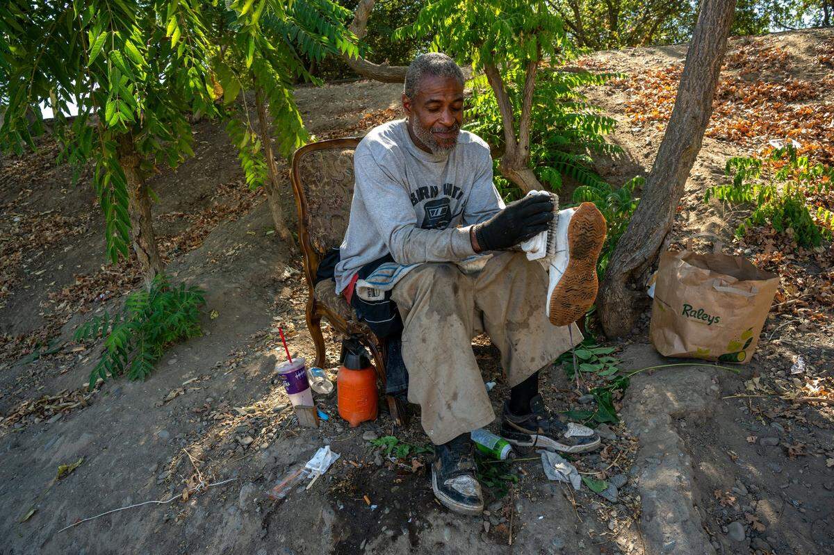 Paris Brazil, 47, sits Wednesday with a bad back trying to clean the few possessions he has after losing his truck and trailer when the city of Sacramento cleared Camp Resolution earlier in the week. He said he decided not to go to the city-offered shelter because he was told his dog was too aggressive. Brazil was upset because he lost the only pictures of his deceased mother during the sweep.