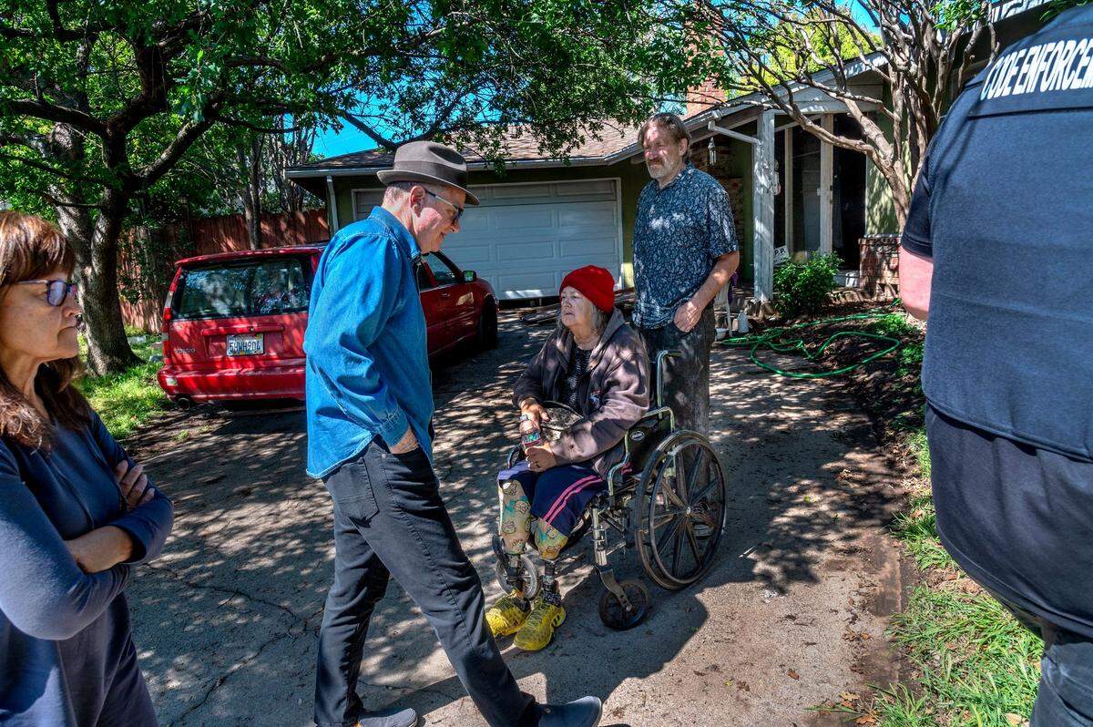 Dan Collins and his wife Lynn Collins, left, with the Bay Area Receivership Group, follow a Sacramento city code enforcement officer past Linda and Bruce Siegrist for an inspection of their Sacramento home in late March. Linda, who uses a wheelchair, is a double amputee and suffers several health issues.