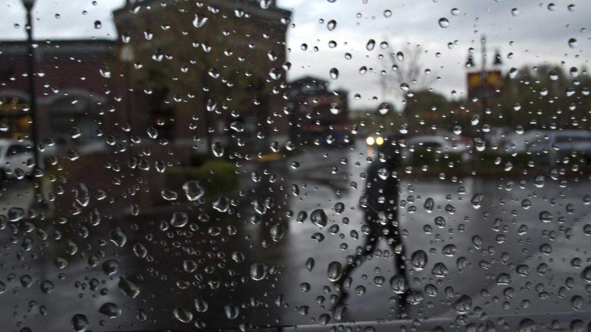 Rain drops cling to a window as a pedestrian crosses the parking lot of the Safeway grocery store at 19th and S streets in Sacramento in 2012. The National Weather Service says a storm bringing rain to the Sacramento Valley and snow to the Sierra Nevada is expected to reach Northern California on Tuesday or Wednesday, just ahead of Thanksgiving.