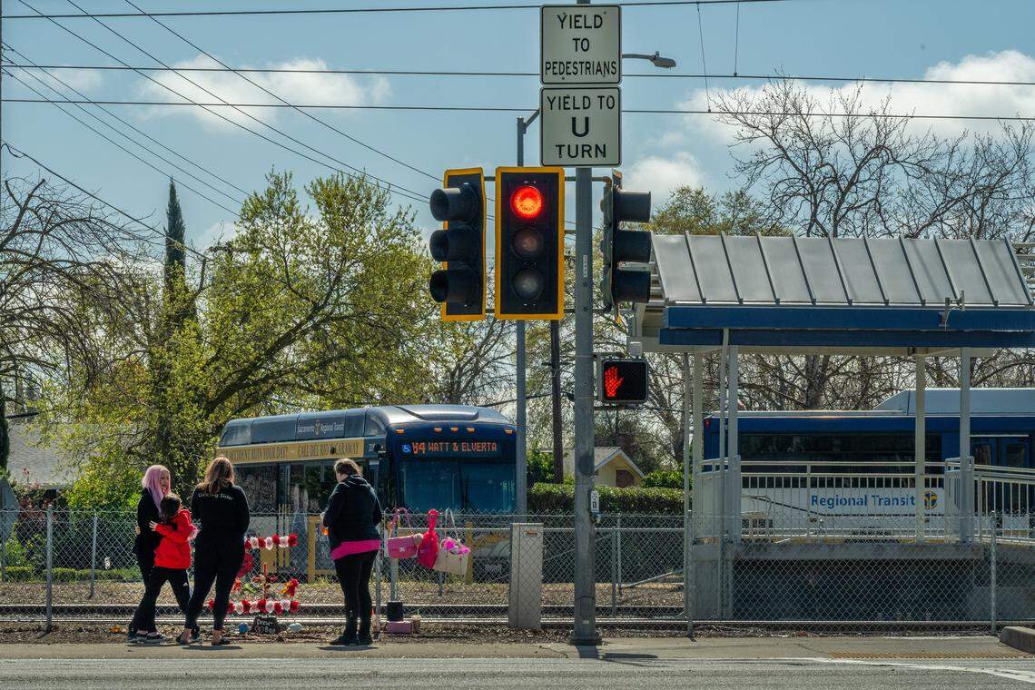 Erika Pringle hugs her son, Ryley French, 10, far left, as she and friends stand near a memorial at the intersection of Folsom Boulevard and Manlove Road, where her brother, Andrew Pringle, was struck and later killed by a motorist while crossing to get lunch before taking the light rail to work. Two years after his death, Erika says she has visited the site twice a week.