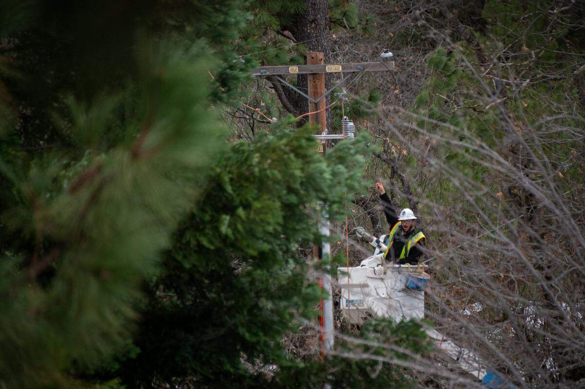 PG&E lineman Matt Mrufka works to restore power on Quail Valley Road near Colfax in 2022, where residents had been without power since a storm blanketed the area with snow the week before.
