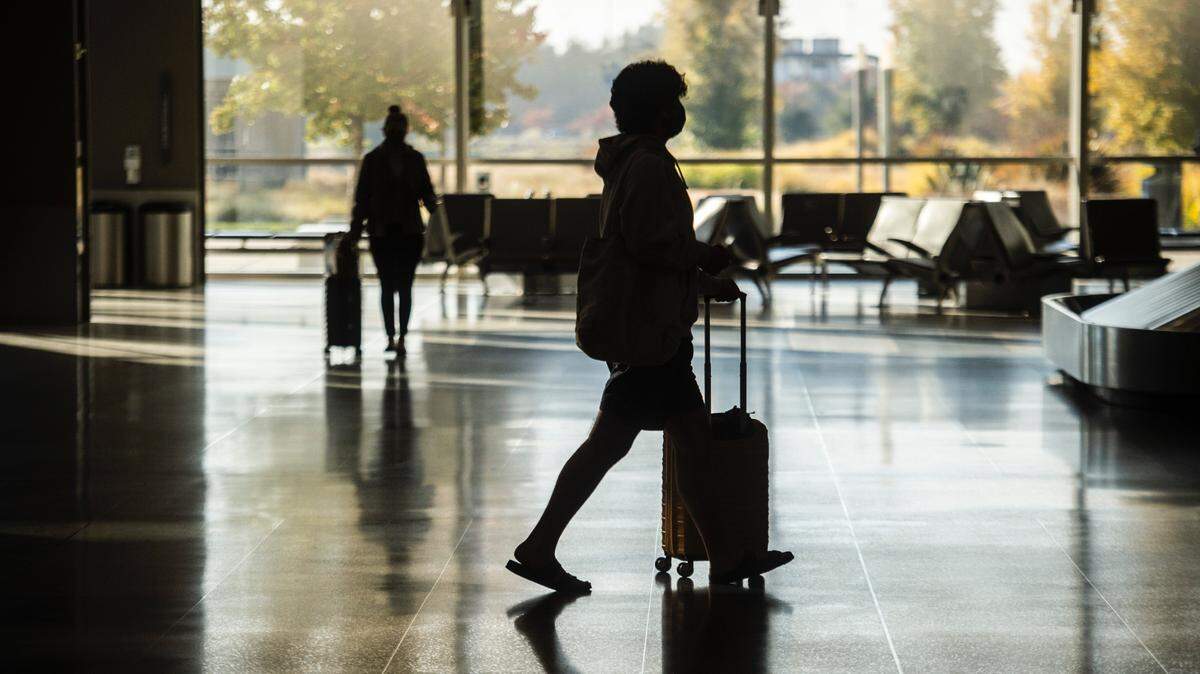 Holiday travelers pick up baggage in terminal B at the Sacramento International Airport on Monday, Nov. 23, 2020.