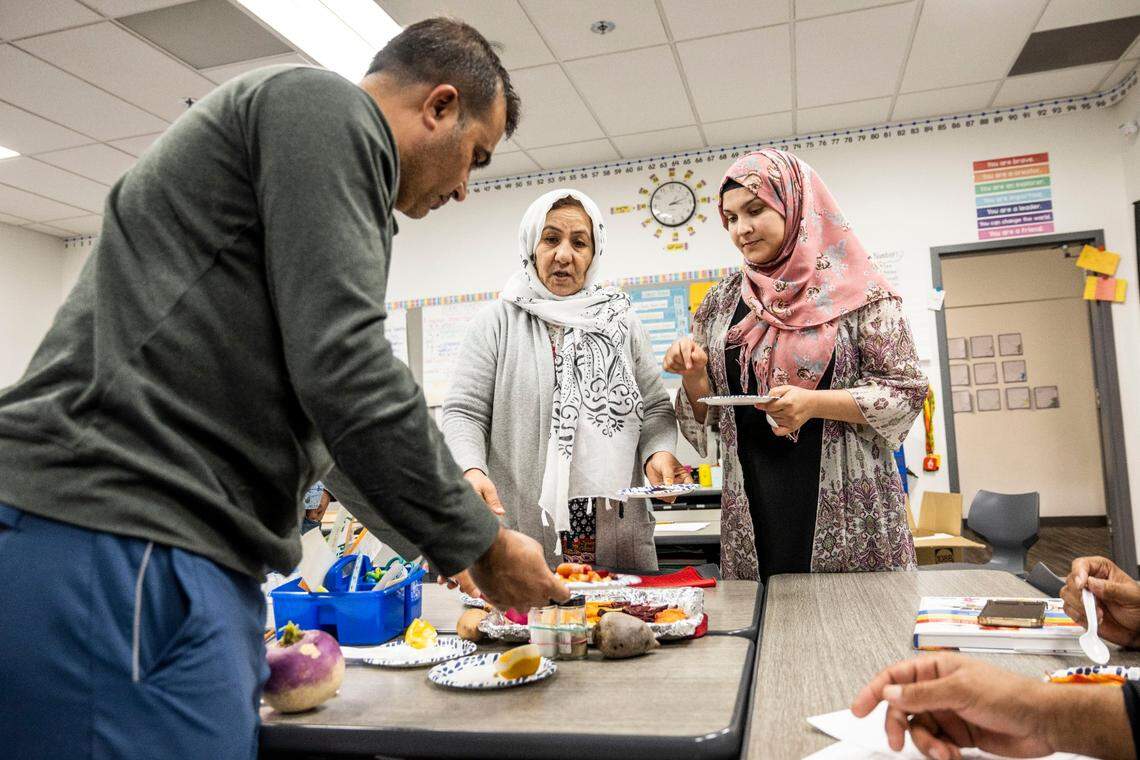 Abdul Wasi Rahimii, left, participates in a cooking class for parents and community members at Dyer-Kelly Elementary School on Feb. 17. The class helps parents feel welcome at school and adjust to cooking with ingredients found in the United States.